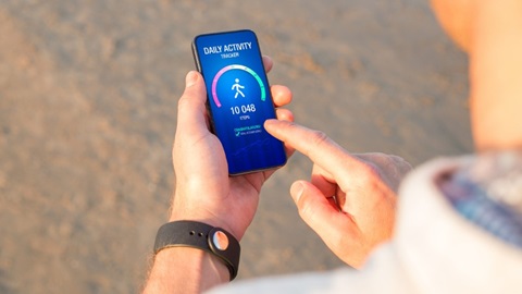 Man houdt smartphone in de hand met daarop de resultaten van een gezondheidsapp